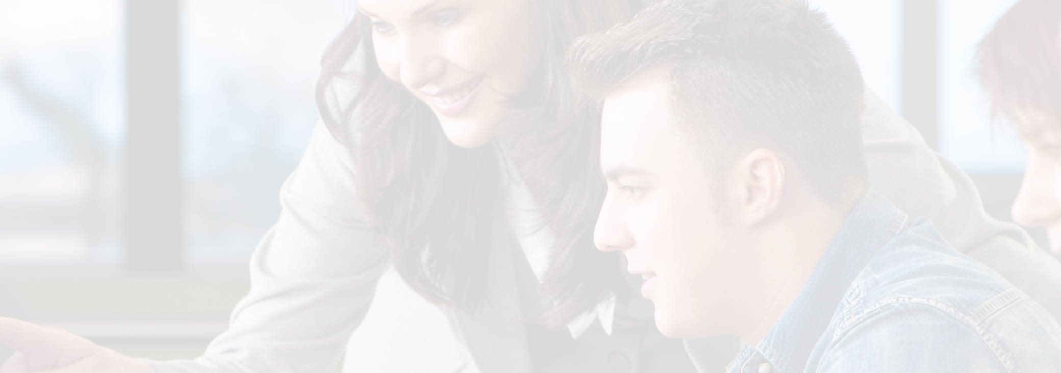 Teacher & group of male and female students using computers at a college