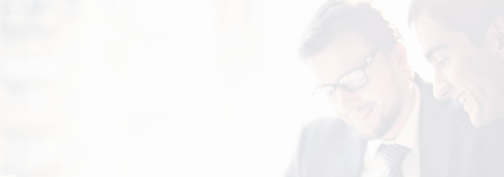 Image of two young businessmen using touchpad at meeting