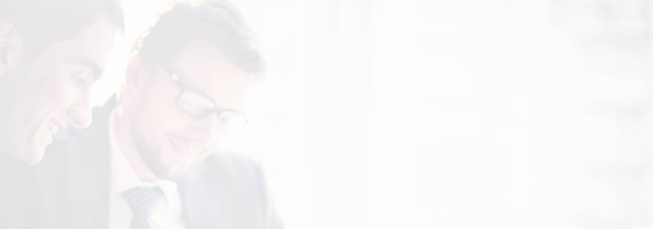 Image of two young businessmen using touchpad at meeting