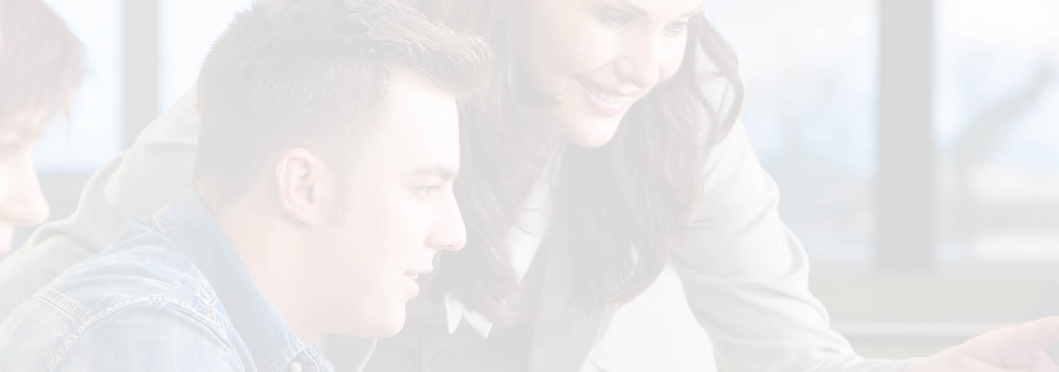 Teacher & group of male and female students using computers at a college