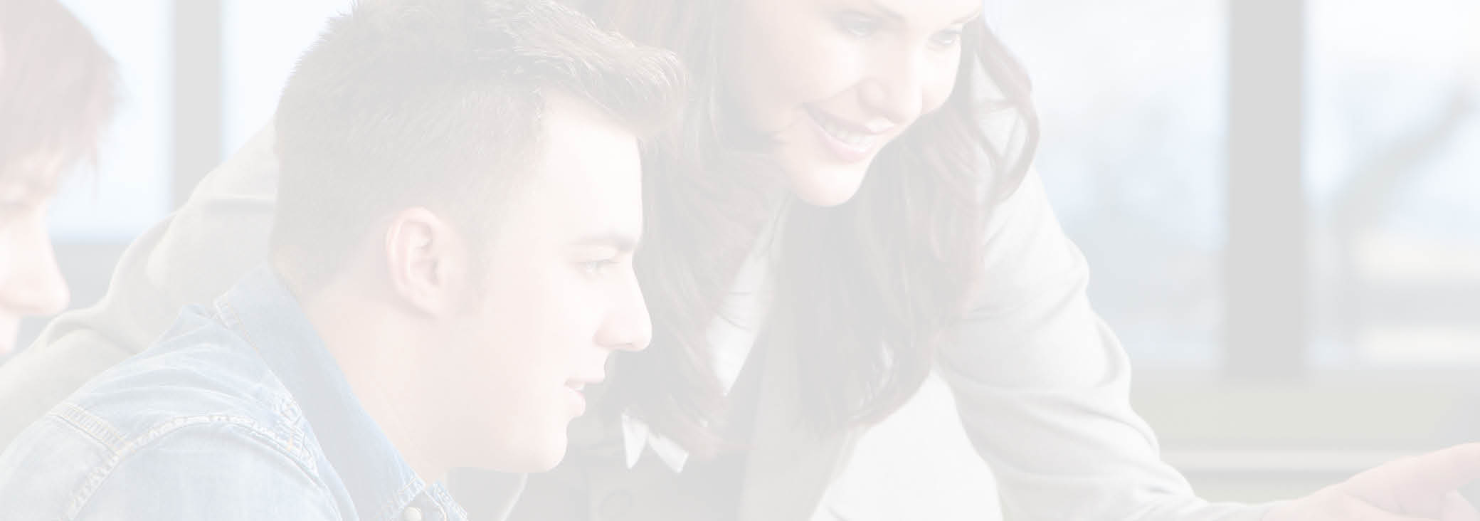 Teacher & group of male and female students using computers at a college